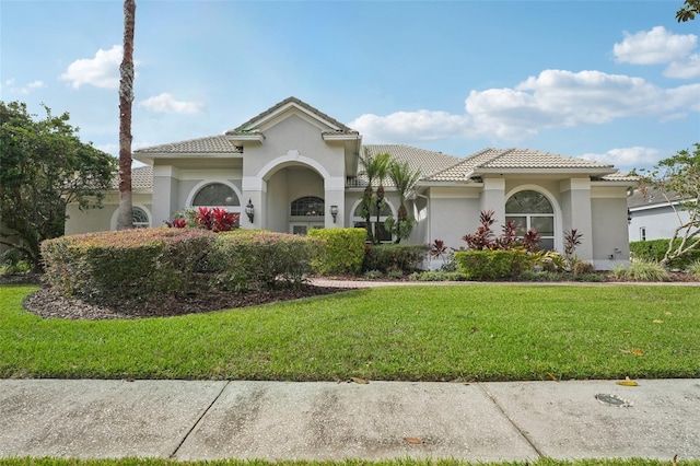 mediterranean / spanish-style home with a front lawn