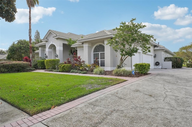 mediterranean / spanish house with a front lawn and a garage