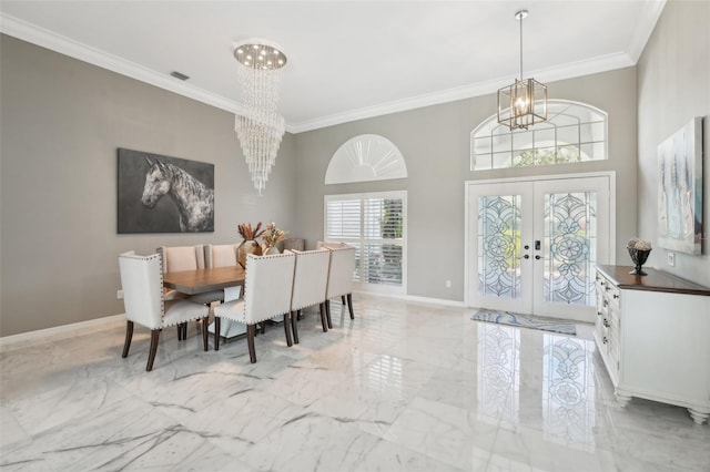 dining room with ornamental molding, french doors, and a chandelier