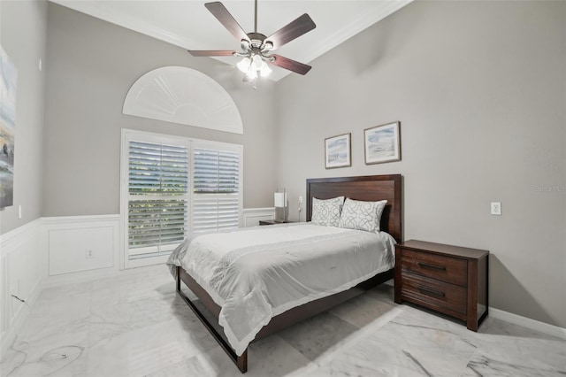 bedroom with a towering ceiling, ceiling fan, and crown molding