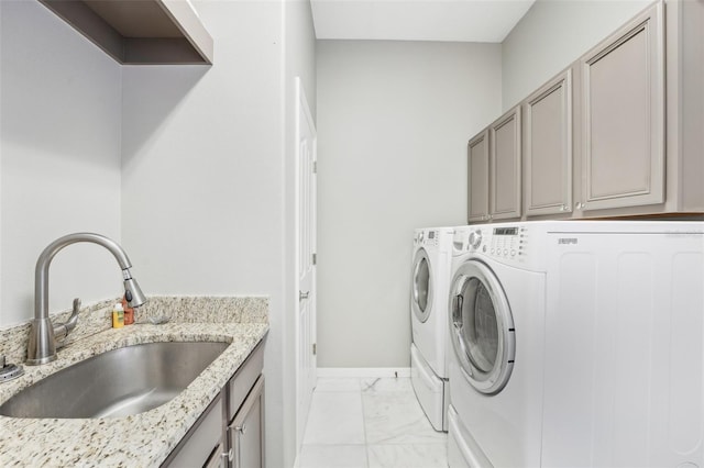 laundry room featuring cabinets, sink, and washing machine and clothes dryer