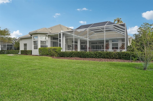 rear view of house with a lanai and a yard