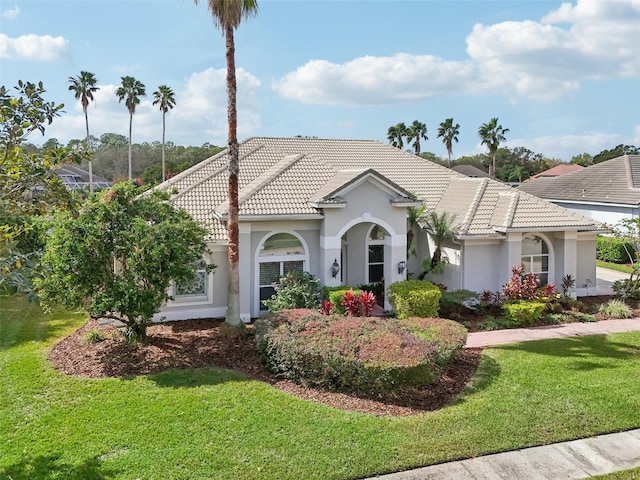 mediterranean / spanish-style home with a front lawn