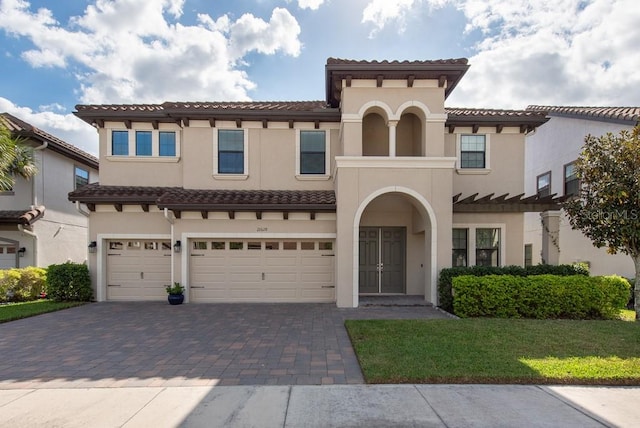 mediterranean / spanish house featuring a front yard and a garage