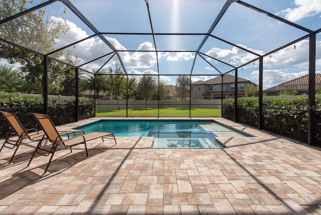 view of pool featuring glass enclosure, a yard, and a patio