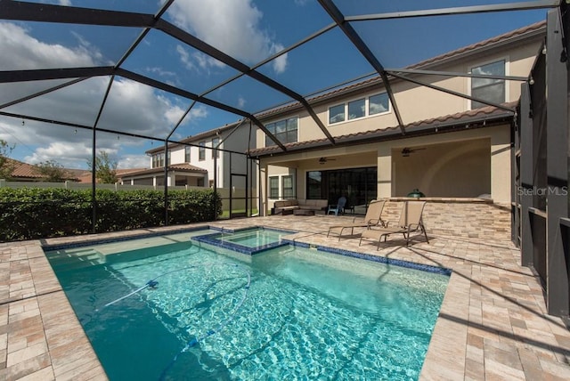 view of swimming pool featuring ceiling fan, an in ground hot tub, a patio, and glass enclosure