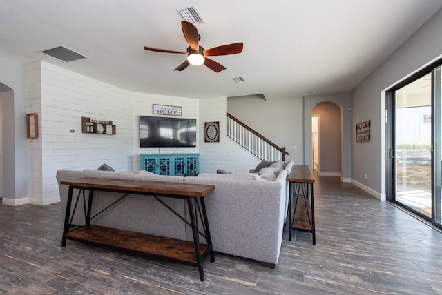 living room featuring ceiling fan and dark wood-type flooring