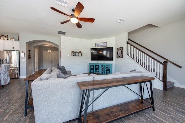 living room featuring ceiling fan and dark wood-type flooring