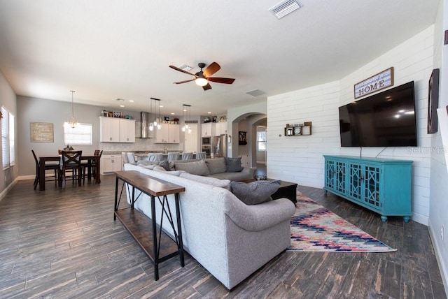 living room featuring dark hardwood / wood-style floors and ceiling fan with notable chandelier