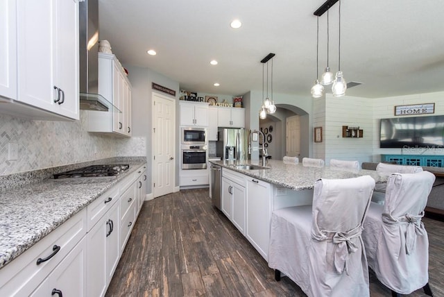 kitchen with white cabinets, appliances with stainless steel finishes, dark hardwood / wood-style flooring, and wall chimney exhaust hood