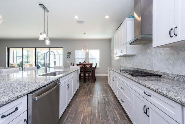 kitchen with wall chimney exhaust hood, stainless steel appliances, sink, dark hardwood / wood-style floors, and plenty of natural light