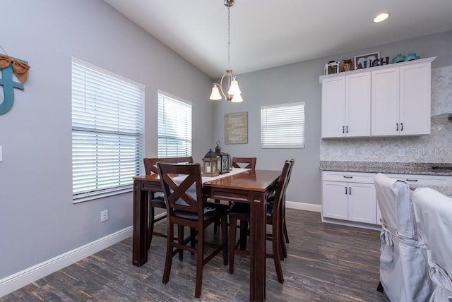 dining area featuring dark hardwood / wood-style flooring and a notable chandelier