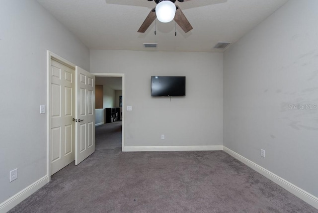 empty room featuring ceiling fan and carpet floors