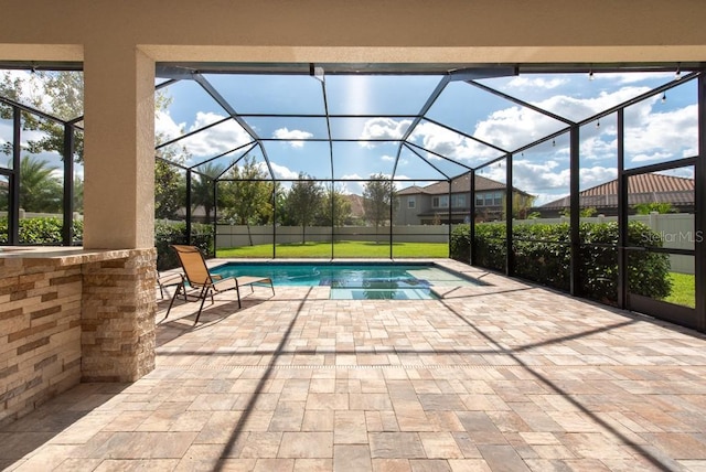 view of pool featuring glass enclosure and a patio area