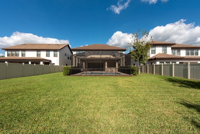 rear view of house featuring a lanai, a fenced in pool, and a yard