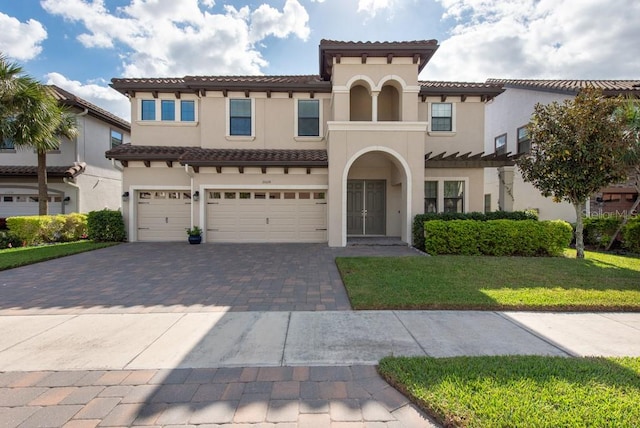 mediterranean / spanish-style house with a garage and a front lawn