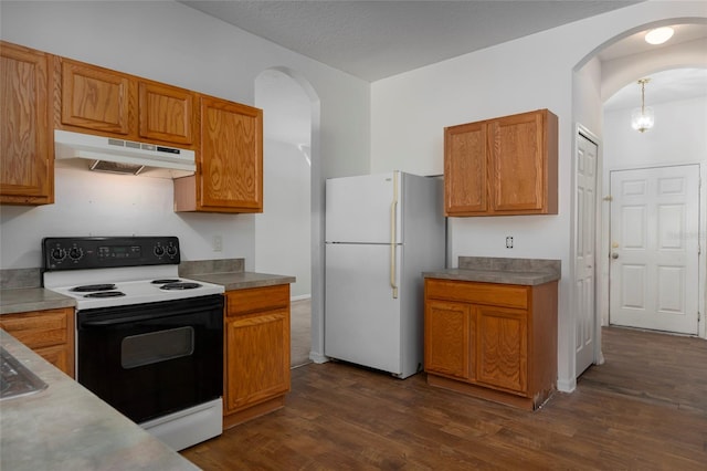 kitchen featuring white appliances and dark hardwood / wood-style floors