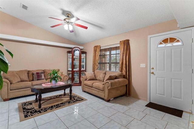 tiled living room featuring ceiling fan, a textured ceiling, and vaulted ceiling