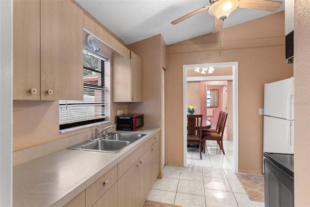 kitchen featuring vaulted ceiling, white fridge, sink, light tile patterned floors, and light brown cabinetry