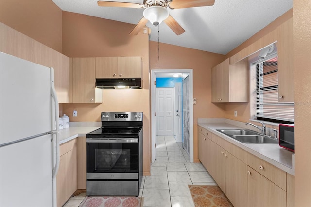 kitchen featuring lofted ceiling, white fridge, stainless steel electric range, sink, and light brown cabinetry