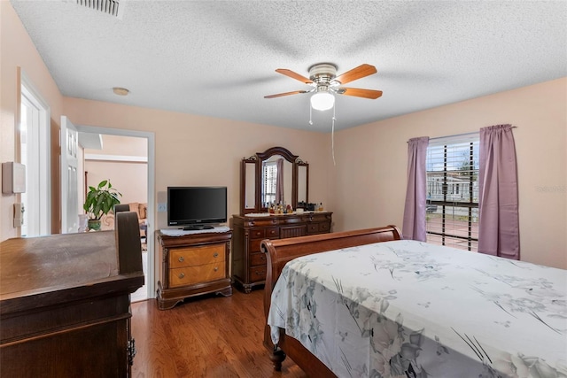 bedroom featuring ceiling fan, a textured ceiling, and dark hardwood / wood-style floors