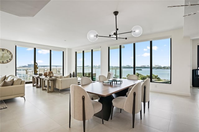 tiled dining room featuring a water view, a wealth of natural light, and an inviting chandelier