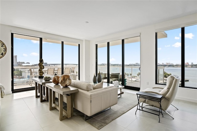 living room with light tile patterned flooring, a water view, and a wealth of natural light