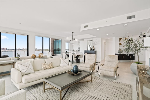 living room with an inviting chandelier and a water view