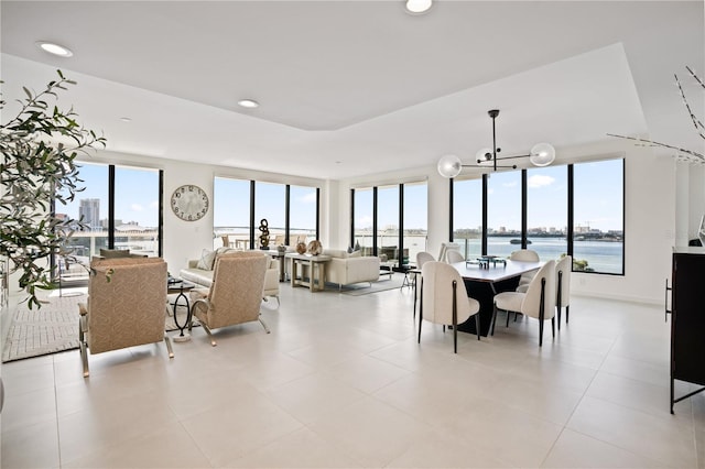 dining area with a water view, a notable chandelier, and plenty of natural light