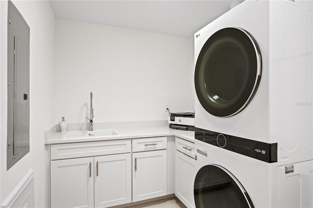 washroom featuring sink, stacked washer / drying machine, electric panel, and cabinets