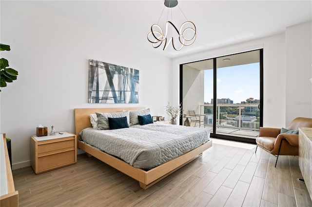 bedroom featuring a notable chandelier, wood-type flooring, and access to exterior