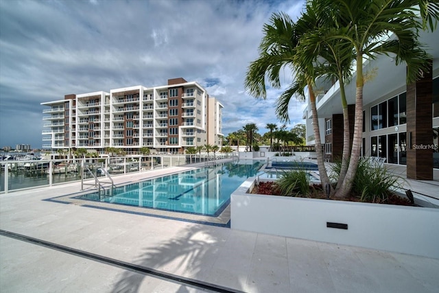 view of pool featuring a patio and a water view