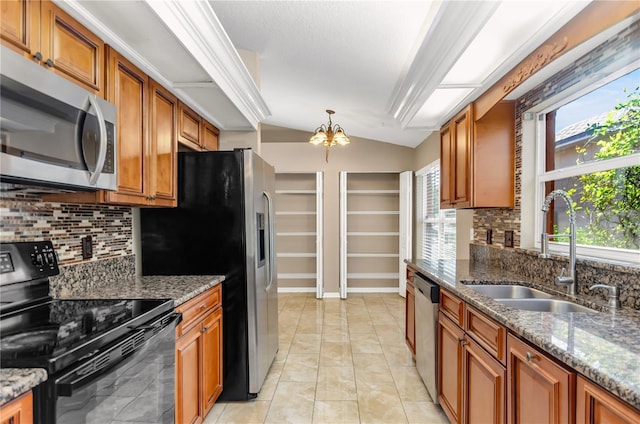 kitchen featuring brown cabinets, a notable chandelier, stainless steel appliances, lofted ceiling, and a sink