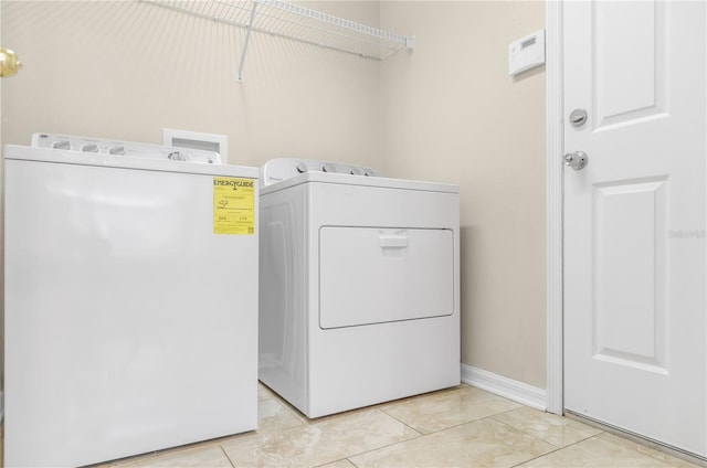 laundry room featuring laundry area, washing machine and dryer, and light tile patterned floors