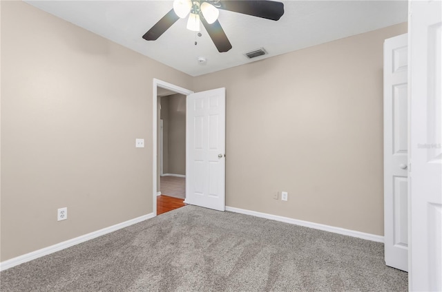 unfurnished bedroom with carpet floors, visible vents, baseboards, and a ceiling fan