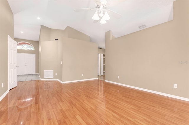 unfurnished living room with lofted ceiling, light wood-style flooring, and baseboards