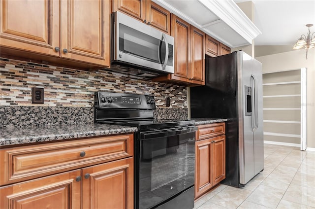 kitchen with stainless steel appliances, brown cabinets, dark stone countertops, and tasteful backsplash