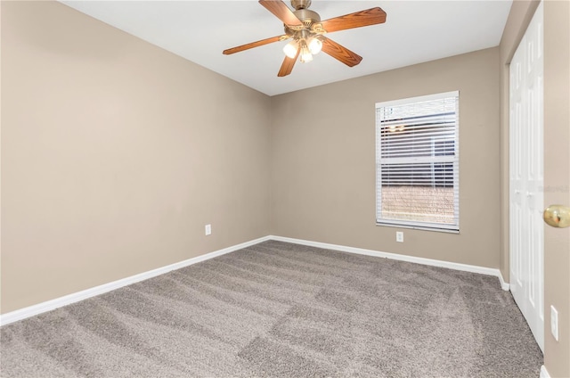 carpeted spare room featuring a ceiling fan and baseboards