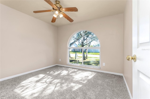 spare room with baseboards, ceiling fan, and carpet