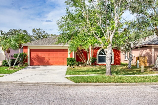 view of front of house with concrete driveway, stucco siding, a garage, and a front lawn