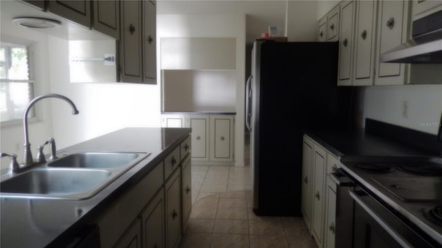 kitchen with dishwashing machine, sink, light tile patterned floors, and stainless steel range with electric stovetop