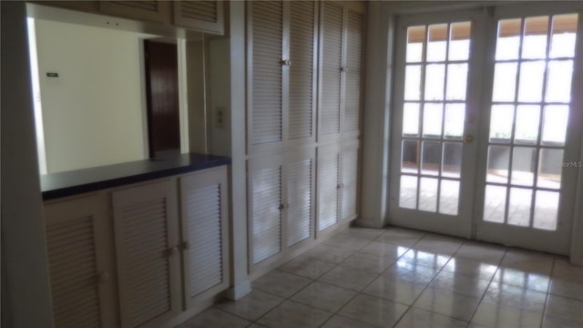 doorway with light tile patterned flooring and french doors