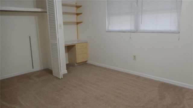 unfurnished bedroom with a closet and light colored carpet