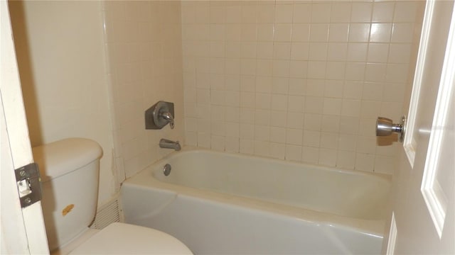 bathroom with toilet and tiled shower / bath