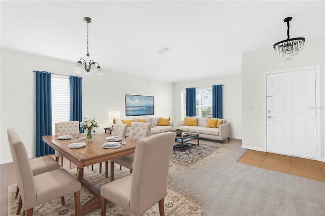 dining area featuring tile patterned floors and a notable chandelier