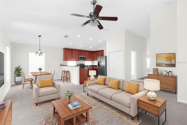 living room featuring ceiling fan with notable chandelier and high vaulted ceiling