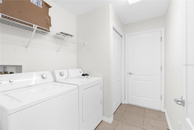 washroom featuring washer and clothes dryer and light tile patterned floors