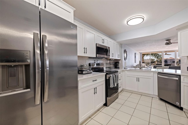 kitchen with light tile patterned flooring, white cabinetry, appliances with stainless steel finishes, backsplash, and sink