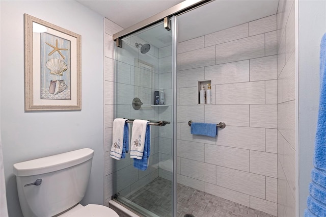 bathroom with toilet and a shower with shower door