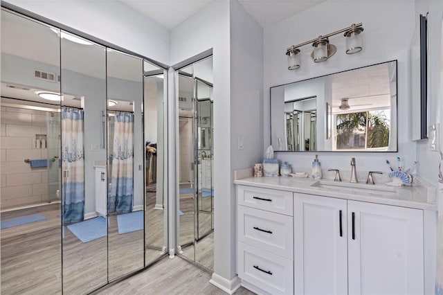 bathroom featuring walk in shower, hardwood / wood-style floors, and vanity